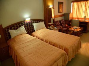 Habitación de hotel con 2 camas y sala de estar. en Hotel City Tower, en Coimbatore