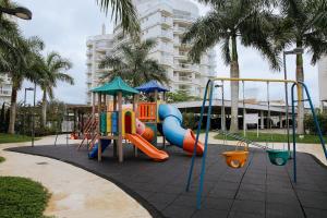 - une aire de jeux avec toboggan dans un parc planté de palmiers dans l'établissement Ap 3 quartos em home club - Beto Carrero/Penha, à Penha