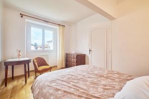um quarto com uma cama, uma mesa e uma janela em Chez Emile em Brézins