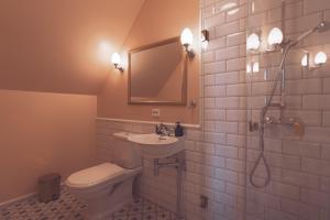 a bathroom with a toilet and a sink and a mirror at Villa Havblikk Tromsø in Tromsø