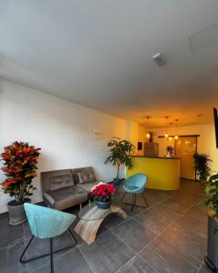 uma sala de estar com um sofá e algumas plantas em Joyfül Accomodation em Finale Ligure