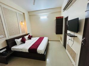a hotel room with a bed and a television at Majestic Heights Hotel in Jaipur