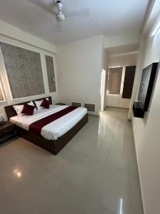 a bedroom with a large bed with red pillows at Majestic Heights Hotel in Jaipur