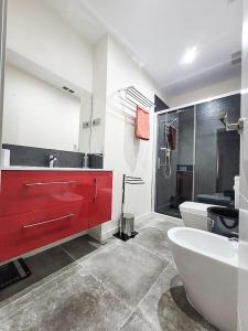 uma casa de banho com um lavatório vermelho e uma banheira em LUJOSO PISO CÉNTRICO EN MURCIA con 3 habitaciones em Múrcia