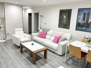 uma sala de estar com um sofá branco e almofadas cor-de-rosa em LUJOSO PISO CÉNTRICO EN MURCIA con 3 habitaciones em Múrcia