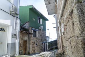 an alley with a green building on the side of a building at U LAGARTU in Eljas