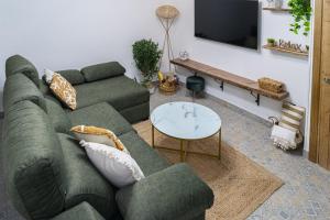 uma sala de estar com um sofá verde e uma mesa em U LAGARTU em Eljas