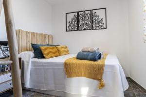 uma cama com almofadas amarelas e azuis em U LAGARTU em Eljas