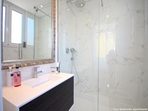 ein Bad mit einem Waschbecken und einer Dusche mit einem Spiegel in der Unterkunft Akicity Liberdade Star in Lissabon
