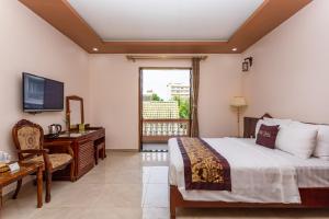 um quarto com uma cama, uma secretária e uma televisão em Phu Van Resort & Spa em Phu Quoc