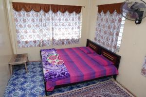 1 dormitorio con cama morada y ventana en 3 BHK-Air Cooler-Fans for 4 to 10 Guests for Families en Hyderabad