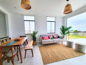 uma sala de estar com um sofá e uma mesa em HERMOSA CASA CON PISCINA FRENTE AL MAR - PRIMERA FILA em Chincha Baja