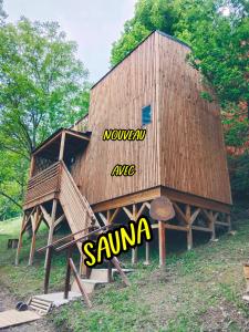 a building with a wooden structure with the word sauna on it at les gites axéens (l'Ours) in Ax-les-Thermes
