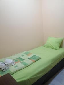 un letto con piumone verde e asciugamani di Квартира 200м от моря. a Bar