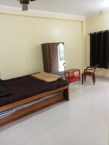 een slaapkamer met een bed en een stoel erin bij Nidhivan Residency in Navadwīp