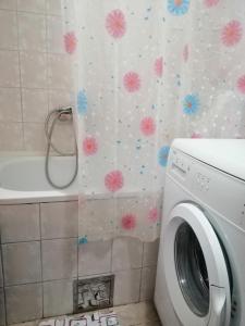 uma máquina de lavar roupa na casa de banho com flores na parede em Квартира 200м от моря. em Bar