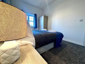 um quarto com uma cama, uma mesa e uma janela em Wallis House by Blue Skies Stays em Stockton-on-Tees