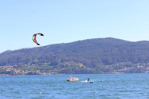 a person flying a kite on a boat in the water at O Refuxio de la Jerezana in Redondela