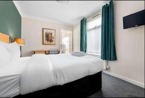 a hotel room with a large bed and a window at Ensuite Room in Cardiff City Centre in Cardiff