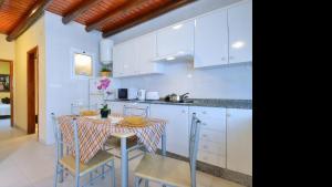 a kitchen with white cabinets and a table and chairs at Apartment Punta di Mare Punta Mujeres By PVL in Punta de Mujeres