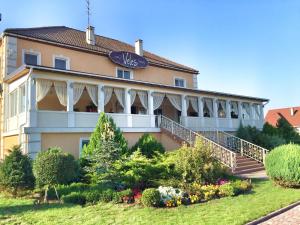 un grand bâtiment avec un jardin en face dans l'établissement Veles Hotel, à Fontanka