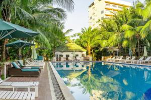 uma piscina num resort com cadeiras e um edifício em Phu Van Resort & Spa em Phu Quoc