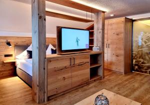 Zimmer mit einem TV auf einem Holzschrank in der Unterkunft Gschwenderhaus Ferienwohnungen in Oberstdorf