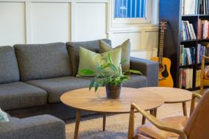 een woonkamer met een bank en een tafel met een plant bij Hestaland Guesthouse Horse Farm Stay in Staðarhús