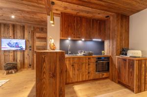 a kitchen with wooden cabinets and a counter top at Modern apartment in Megeve near ski lifts in Megève