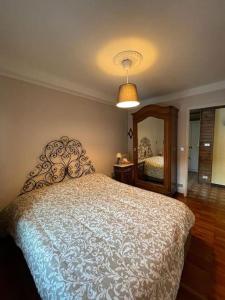 a bedroom with a large bed and a mirror at Villa Gatti [Limone Centro] in Limone Piemonte