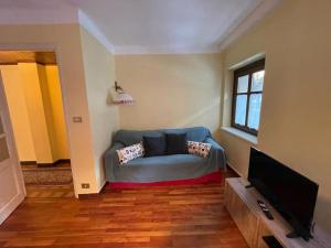 a living room with a couch and a tv at Villa Gatti [Limone Centro] in Limone Piemonte