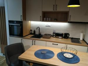 a kitchen with a wooden table with a wooden counter top at Apartman Grujanac in Zlatibor +14 photos