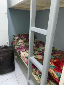ドバイにあるBright Roomsの二段ベッド2台とスーツケースが備わる客室です。
