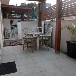 un patio con 2 sillas y una mesa en un patio en Moradas Lagoinha, en Florianópolis