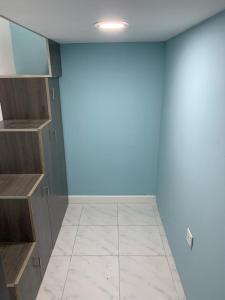 ドバイにあるBright Roomsの青い壁とタイルフロアの客室です。
