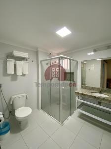 a bathroom with a toilet and a glass shower at Piazza diRoma com acesso ao Acqua Park in Caldas Novas