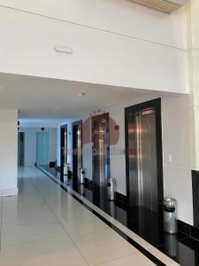a long hallway with silver elevators in a building at Piazza diRoma com acesso ao Acqua Park in Caldas Novas