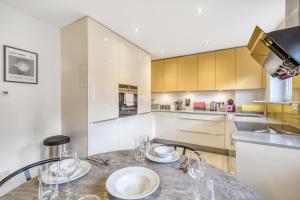 a kitchen with a table with glasses on it at Executive 4 Bedroom Town House in Canada Water FREE WIFI & PARKING by City Stay Aparts London in London