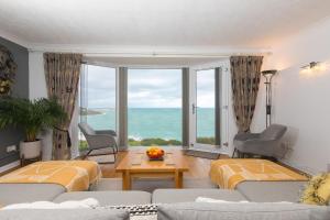 Una sala de estar con un sofá y una ventana grande. en Ocean Edge, en St Ives