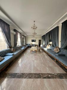 un ampio soggiorno con divani e tavolo di كورال بيت العطلات a Al Khobar