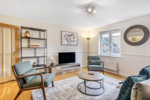 a living room with a couch and chairs and a tv at Executive 4 Bedroom Town House in Canada Water FREE WIFI & PARKING by City Stay Aparts London in London