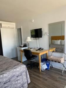 um quarto de hotel com uma secretária, uma cama e um quarto em Motel Centre-Ville em Montmagny