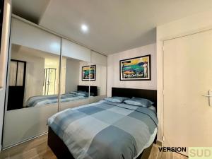 una camera da letto con un grande letto con specchi di Version SUD : Cosy appartement centre ville a Tolone