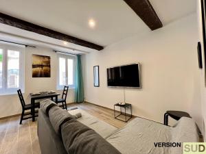 un soggiorno con divano e TV di Version SUD : Cosy appartement centre ville a Tolone