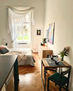 a bedroom with a bed and a table and a window at Robins Nest in The City Center in Maribor