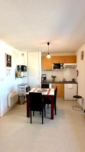 a kitchen and dining room with a table and chairs at Résidence Les Balcons du Pic d'Anie in Arette