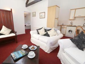a living room with a white couch and a table at 1 Bed in Boulmer 60516 in Boulmer