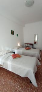 three beds in a room with white walls at Appartamento Levante in Bari