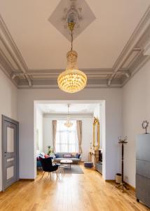 a living room with a couch and a chandelier at House of Lara in Brussels