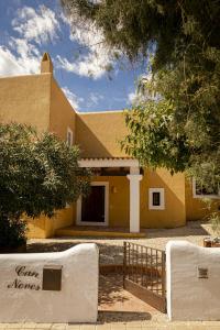 een geel huis met een hek ervoor bij Can Noves - Villa de 5 suites 28 y 58 in Sant Francesc Xavier